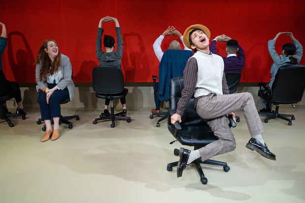 Actors dance in swivel chairs. 