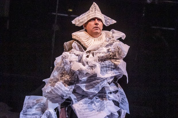 A man wears a suit made out of tissue paper sheet music. 