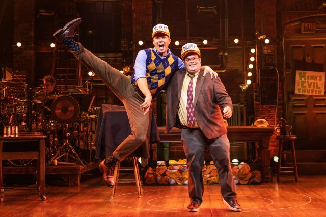 Andrew Rannells kicks his right leg up in the air ala <I>Oklahoma!</I>, while Josh Gad supports him and smiles dimly. 